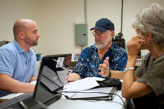 people discussing auto insurance claim in office