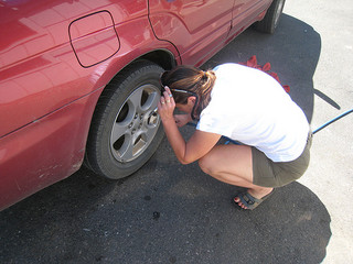 woman pumping tyre on side road